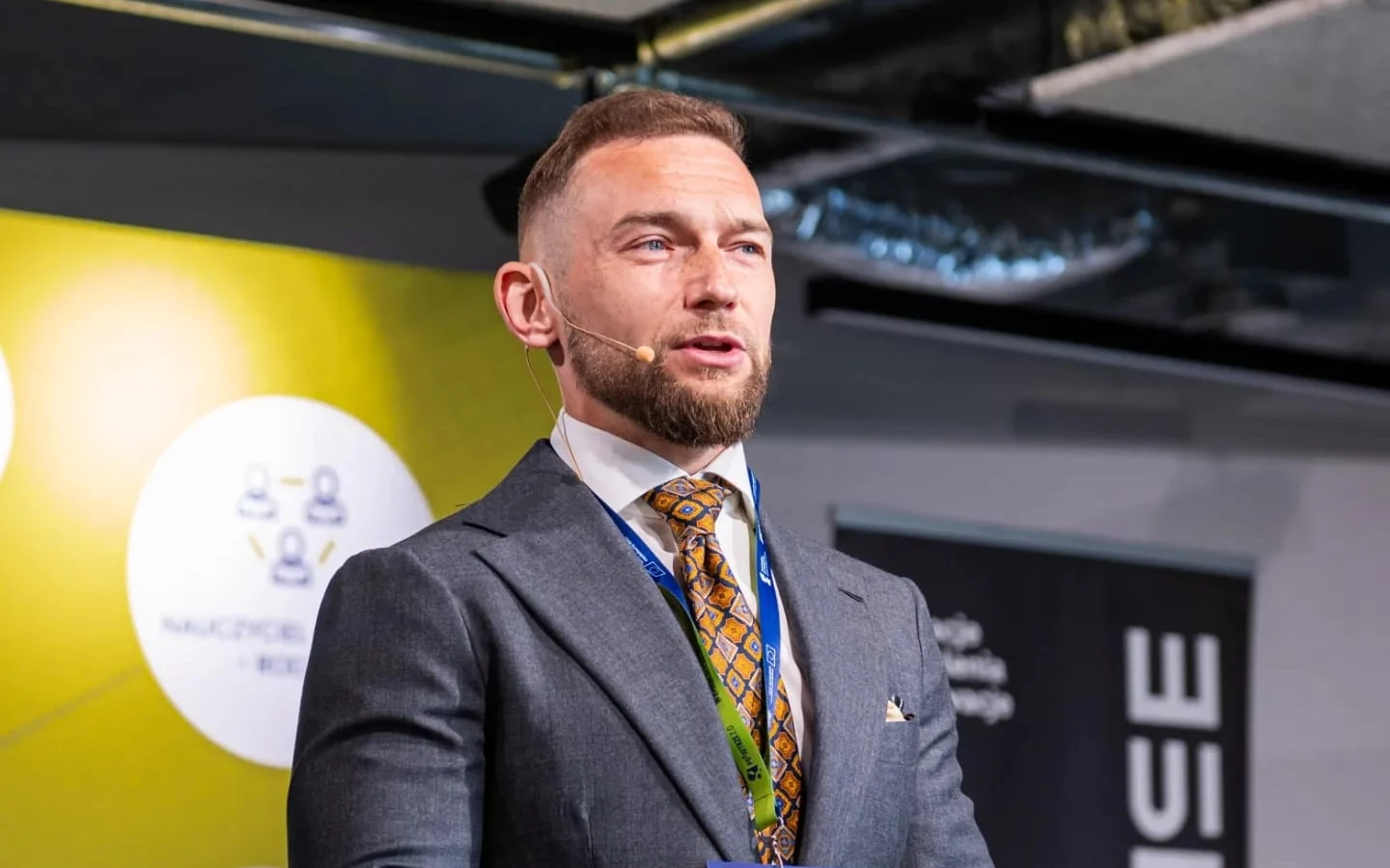 Marcin Bielicki podczas wystąpienia z mikrofonem nagłownym